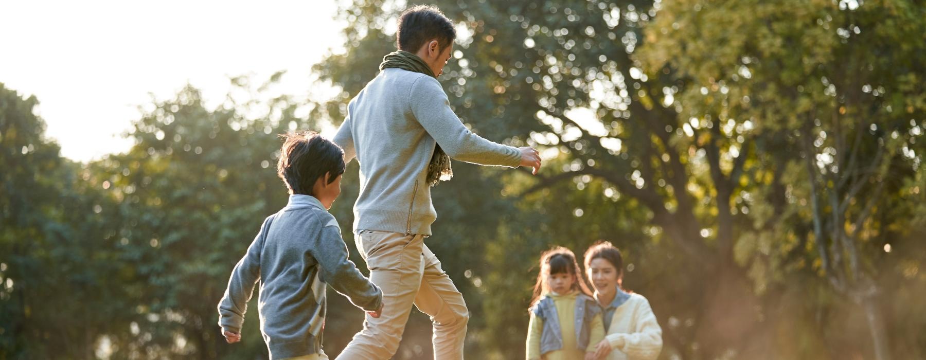 a man and a woman playing with a child in a grassy field